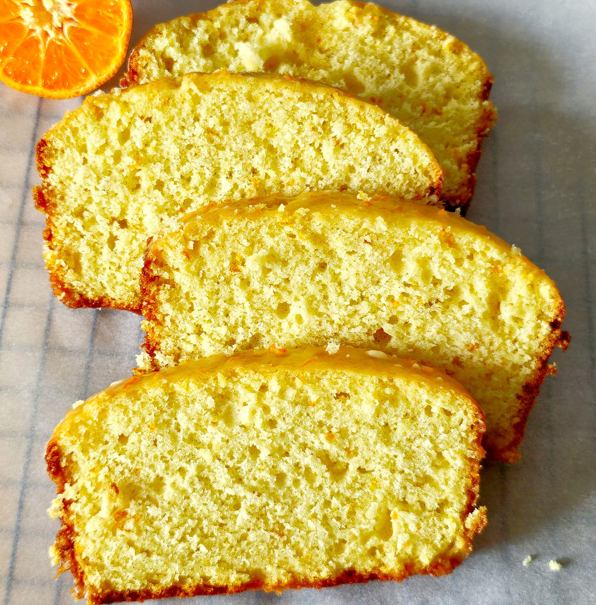 orange loaf cake slices kept on parchment paper