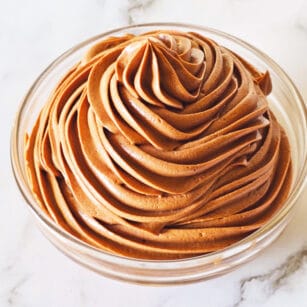 Piped chocolate cream cheese frosting in a small glass bowl