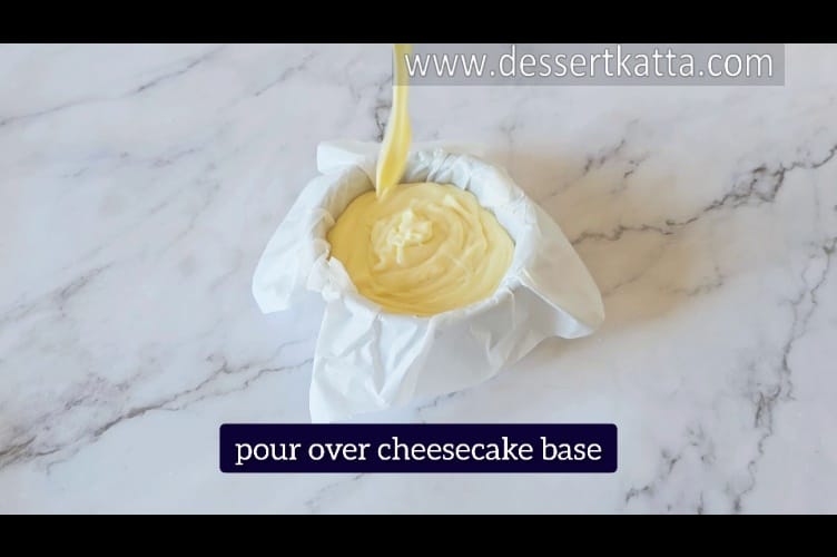 pouring cheesecake filling over cheesecake base in regular pan