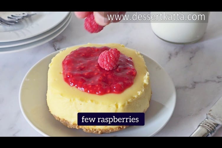 adding raspberries on top of New York cheesecake