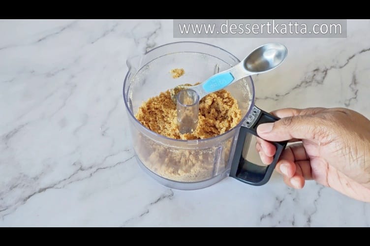 mixing bowl containing crushed digestive biscuits and butter