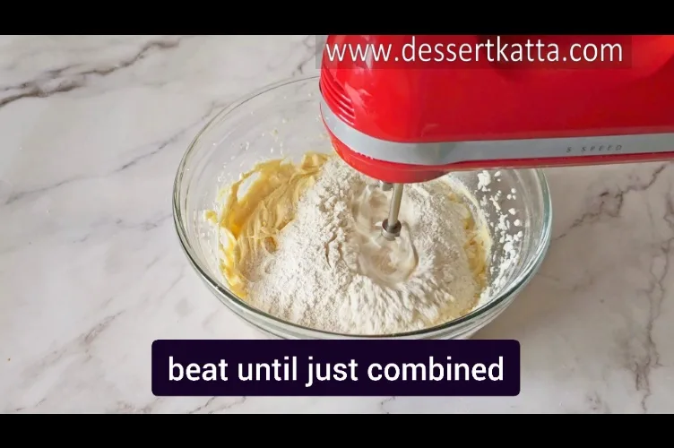 beating sifted dry ingredients into cake batter with hand beater