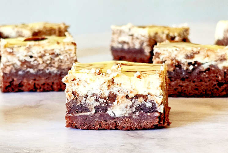 front shot of chocolate cheesecake brownies with few in the background