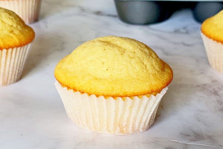 easy vanilla muffins with cupcake pan and 3 muffins in the background