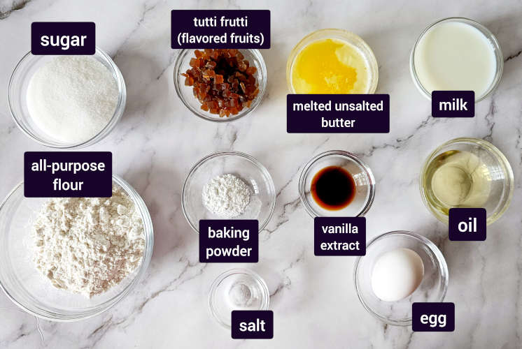 Tutti frutti loaf cake ingredients placed on marble surface