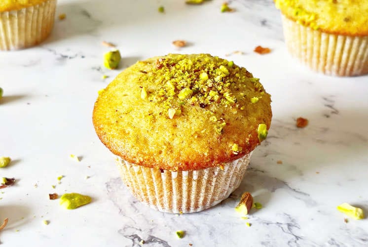 side shot of muffins topped with lots of pistachios