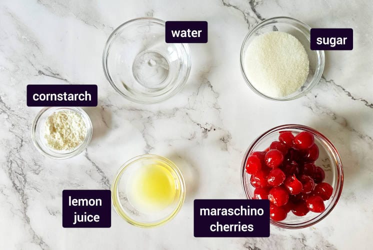 ingredients for cherry compote are placed on marble background in small bowls