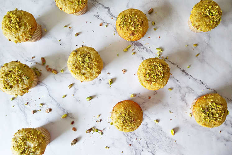 top shot of pistachio muffins placed on marble surface