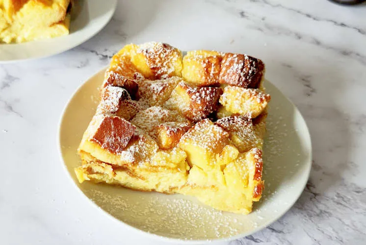 Ingredients for overnight bread roll pudding casserole including eggs milk cinnamon and bread rolls