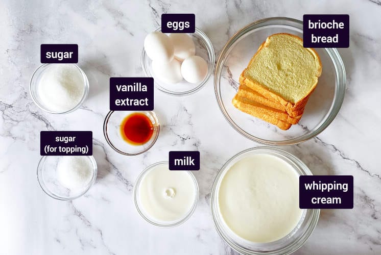 ingredients for vanilla bread pudding are placed on marble background in small bowls to prepare chocolate Nutella cake