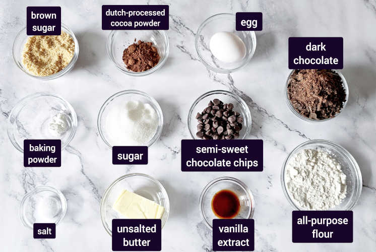 ingredients for chocolate brownies cookies are placed on marble background in small bowls